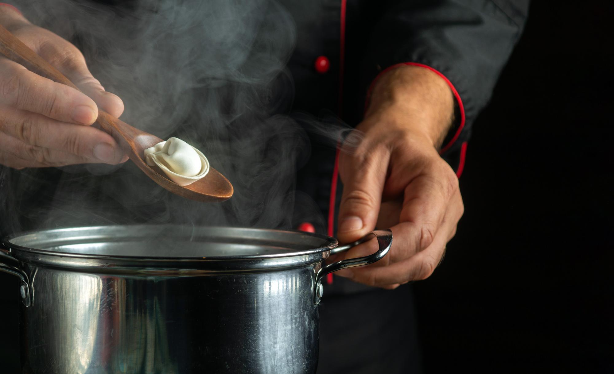 Close-up of hands seasoning a sauce in a pan