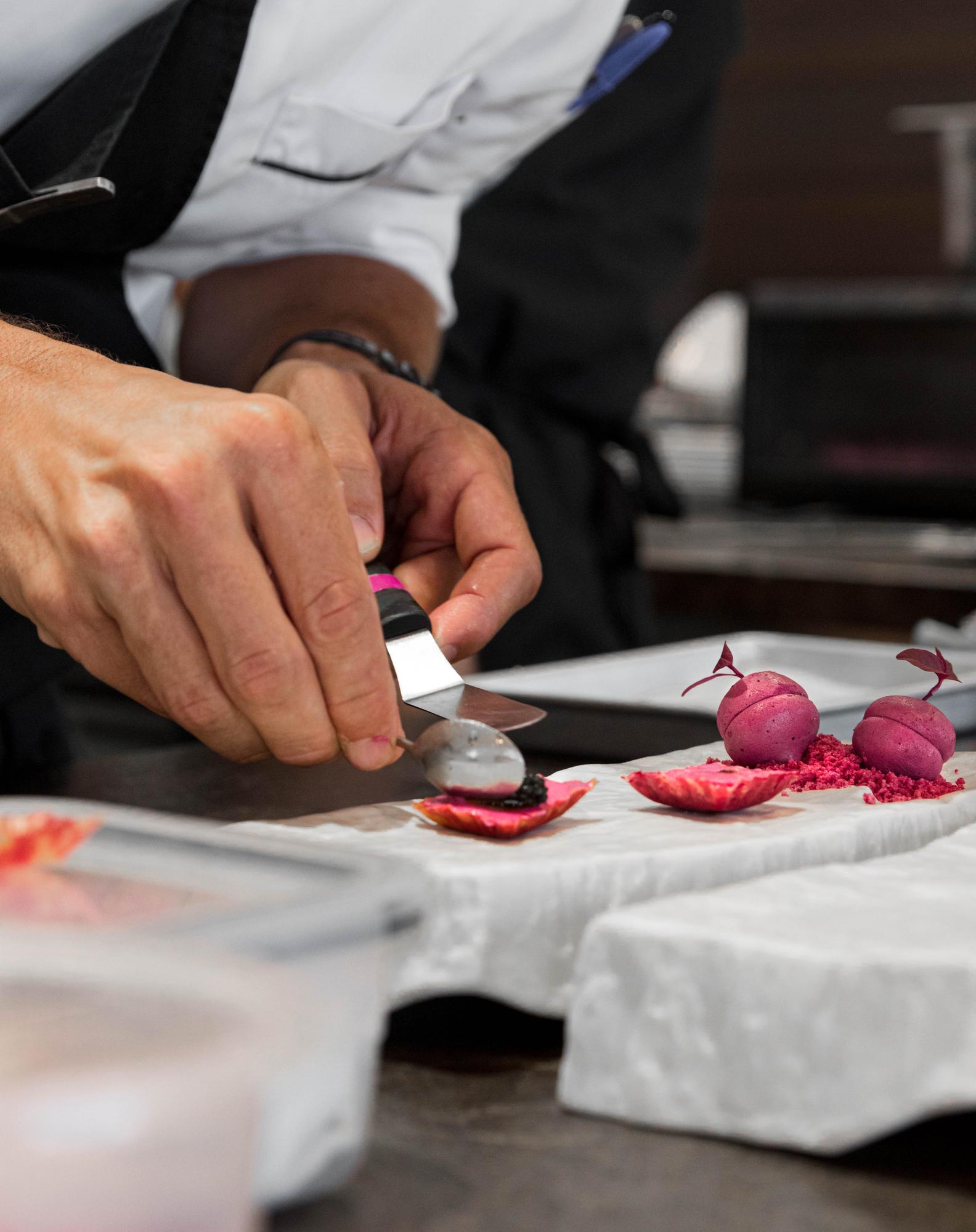 Chef teaching a small class, demonstrating knife technique